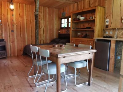 Cabane en bois à Nouvelle-Aquitaine, avec un intérieur chaleureux et mobilier en bois.