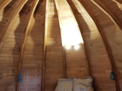 Cabane en bois avec un plafond en bois sculpté et un lit douillet.