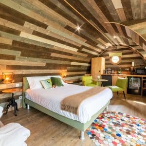 Hébergement insolite en Bourgogne : chambre au design bois avec un tapis coloré.
