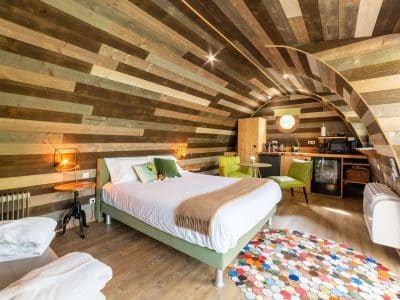 Hébergement insolite en Bourgogne : chambre au design bois avec un tapis coloré.