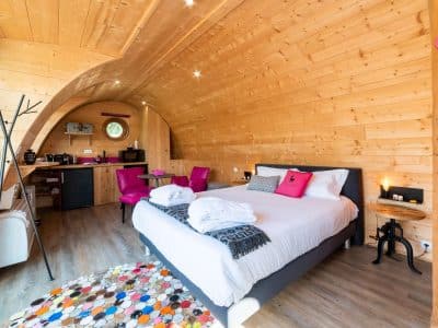 Hébergement insolite en Bourgogne : chambre en bois avec lit douillet et décor coloré.