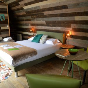 Chambre dhôtes en bois avec lit douillet et décoration colorée à Bourgogne.
