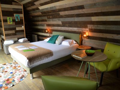 Chambre dhôtes en bois avec lit douillet et décoration colorée à Bourgogne.