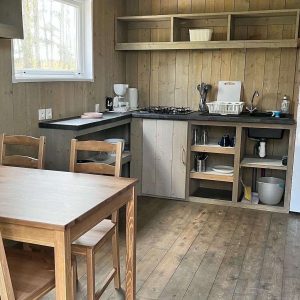 Cabane en bois à Pays de la Loire, avec cuisine équipée et mobilier en bois naturel.