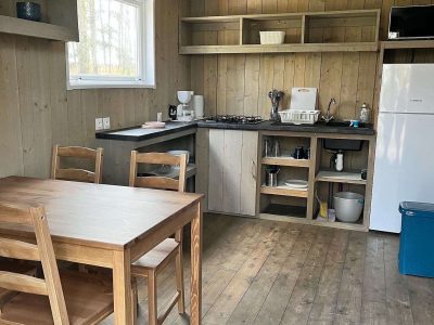 Cabane en bois à Pays de la Loire, avec cuisine équipée et mobilier en bois naturel.