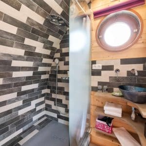Douche moderne dans un hébergement insolite en bois en Bourgogne, ambiance chaleureuse.