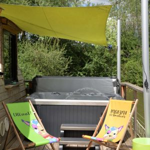 Hébergement insolite en Bourgogne avec jacuzzi et chaises longues colorées sur la terrasse.