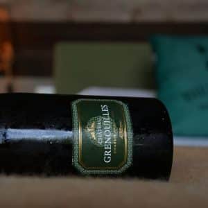 Hébergement insolite en Bourgogne avec une bouteille de vin et un coussin décoratif.