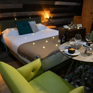 Chambre romantique en hébergement insolite, décorée de bougies et dune table élégante.