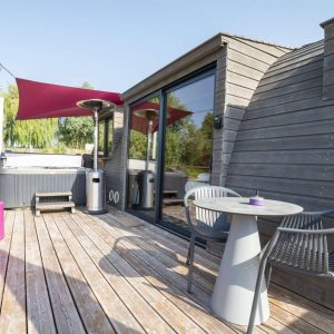 Hébergement insolite en Bourgogne : cabane moderne avec terrasse et jacuzzi.