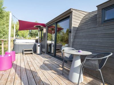 Hébergement insolite en Bourgogne : cabane moderne avec terrasse et jacuzzi.