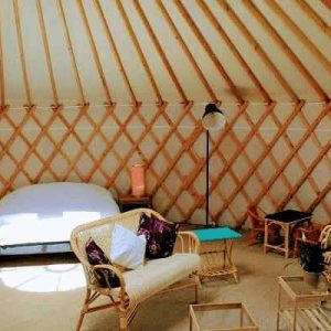 Yourte spacieuse au Centre, avec lit douillet et mobilier en rotin chaleureux.