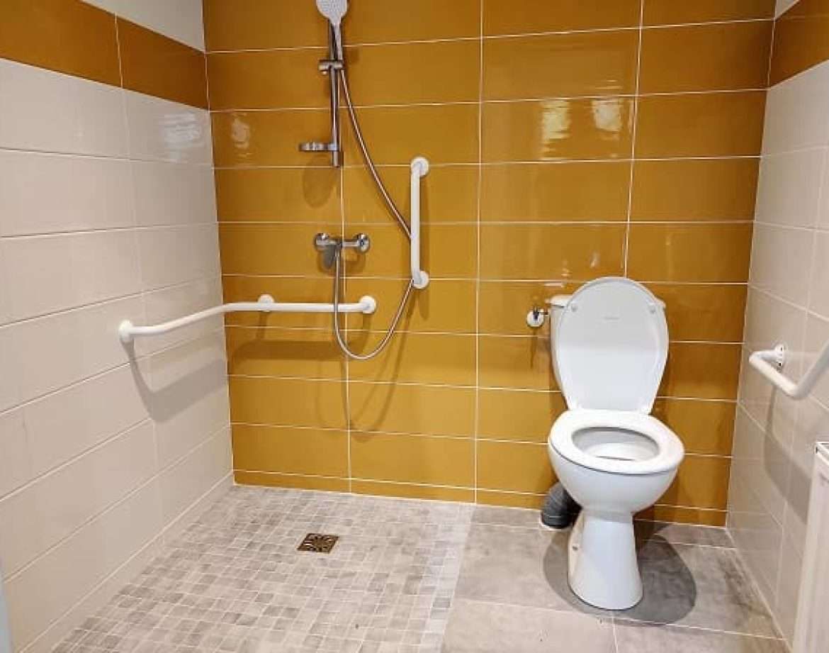 Salle de bain moderne dun hébergement insolite avec douche et toilettes.