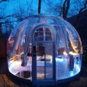 Bulle transparente illuminée, offrant une vue sur la nature en Auvergne-Rhône-Alpes.