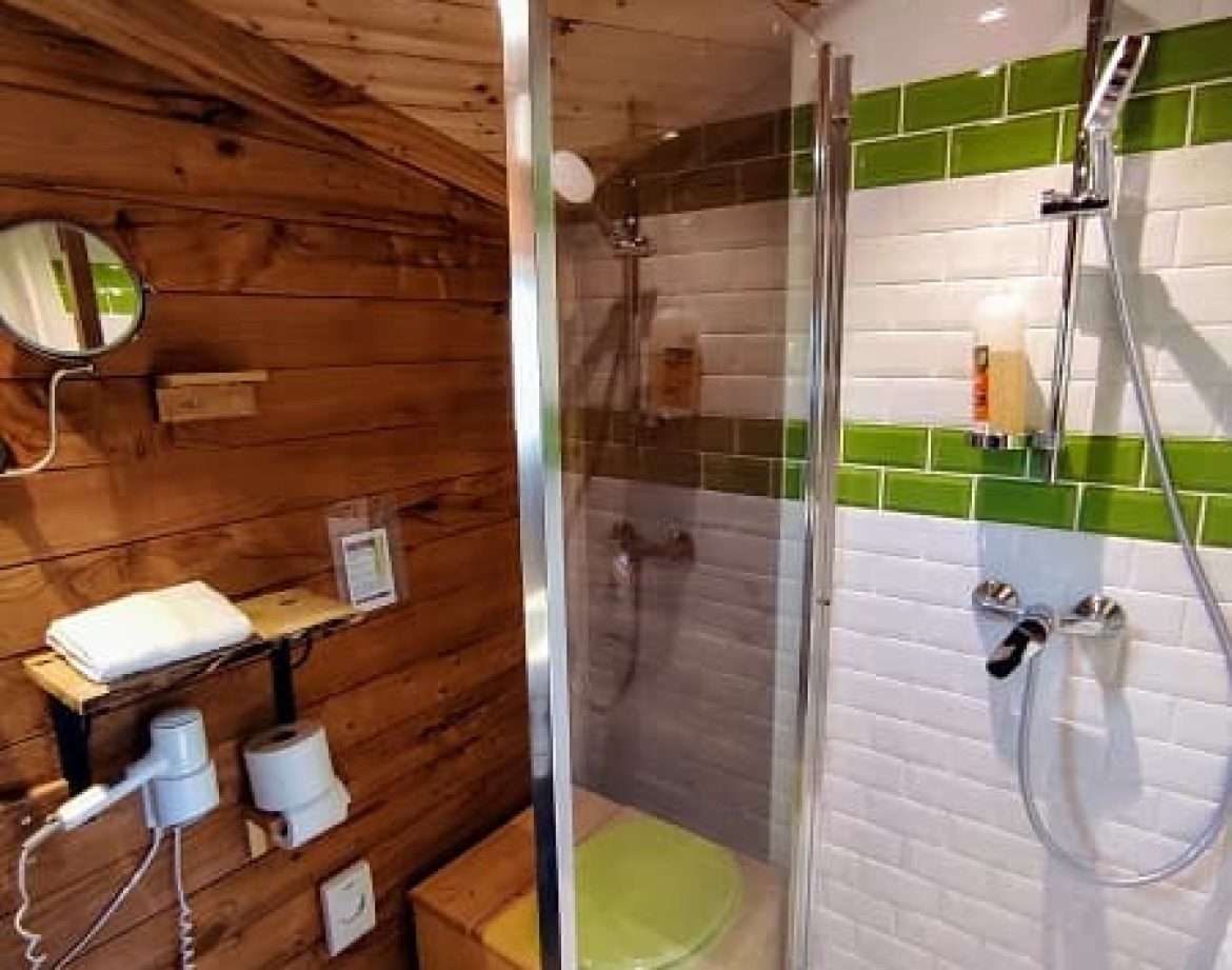 Douche moderne dans un hébergement insolite en bois au Centre, ambiance chaleureuse.