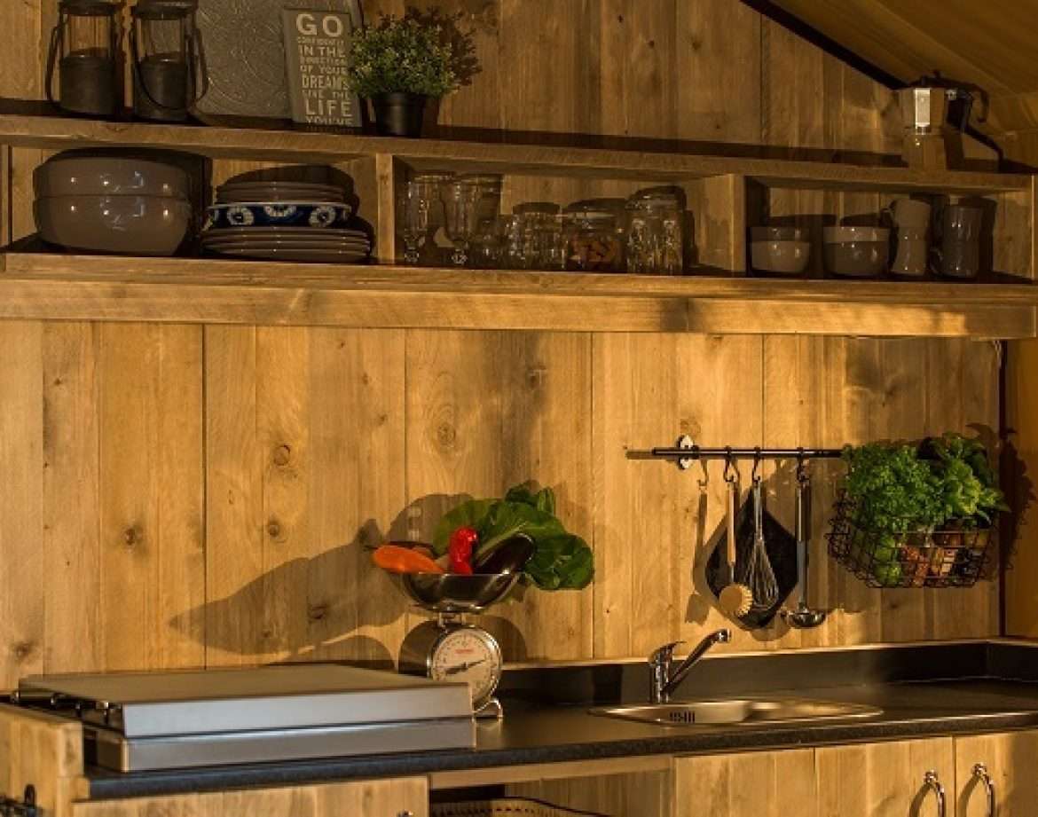 Hébergement insolite en bois avec cuisine équipée et étagères décoratives.