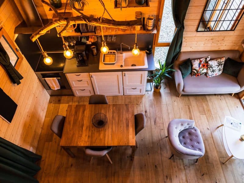 Chalet moderne en bois avec cuisine équipée et table en bois chaleureuse.