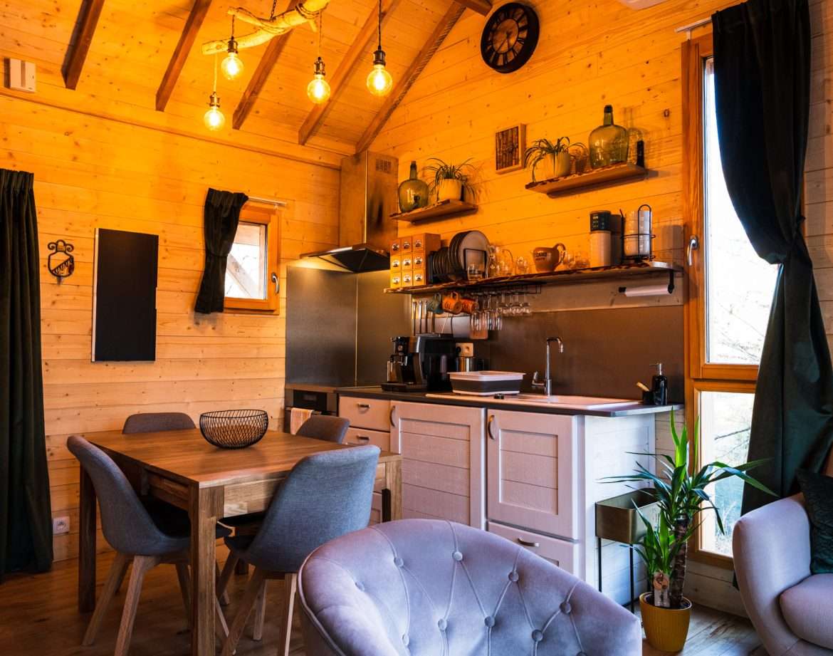 Cabane en bois chaleureuse avec cuisine équipée et décoration cosy.