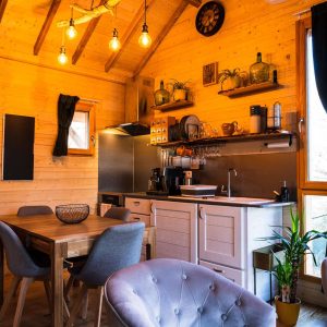 Cabane en bois chaleureuse avec cuisine équipée et décoration cosy.