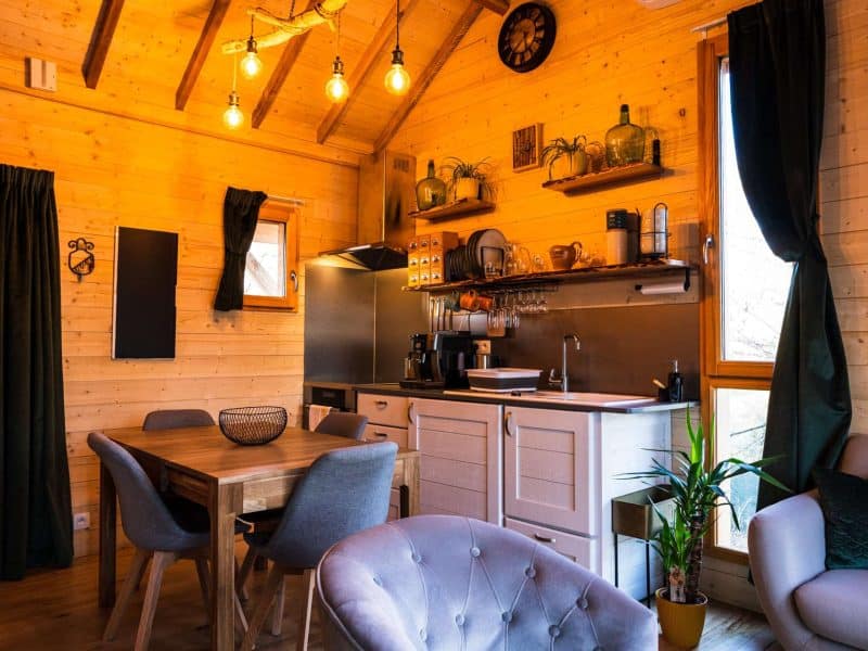 Chalet en bois chaleureux avec cuisine moderne et ambiance cosy.