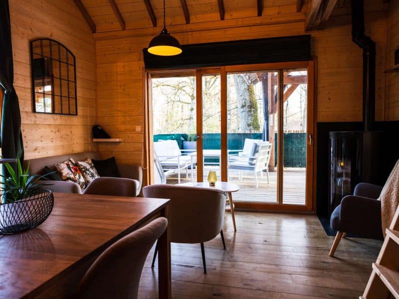 Chalet en bois chaleureux avec salon lumineux et terrasse en bois.