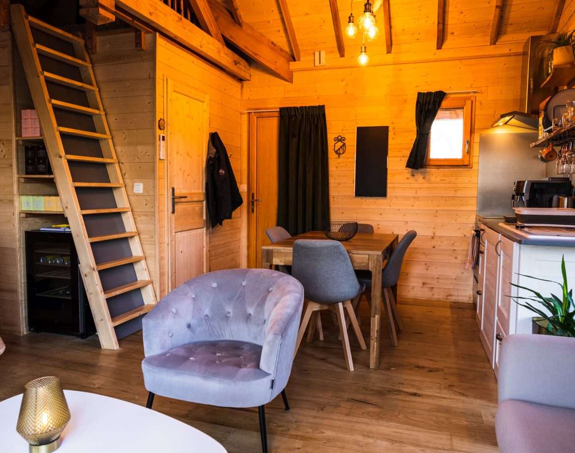 Cabane en bois chaleureuse avec un escalier menant à une mezzanine.