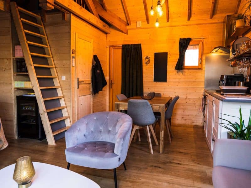Chalet en bois chaleureux avec un coin salon et une cuisine moderne.
