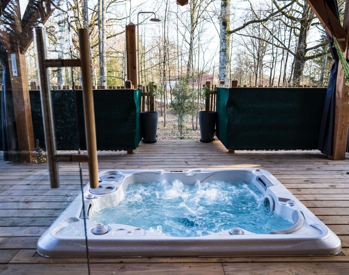 Hébergement insolite en bois avec jacuzzi, entouré de nature apaisante.