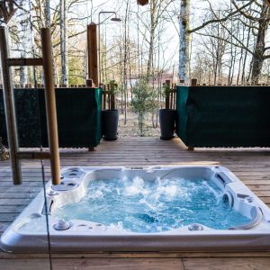 Hébergement insolite en bois avec jacuzzi, entouré de nature apaisante.