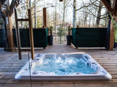 Hébergement insolite en bois avec jacuzzi, entouré de nature apaisante.