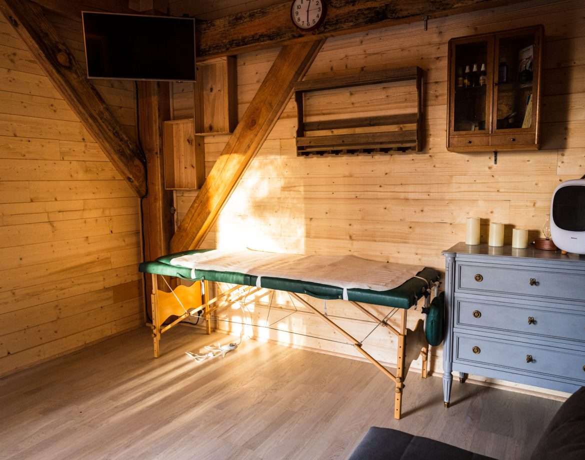 Hébergement insolite en bois avec un espace bien-être et un lit de massage.