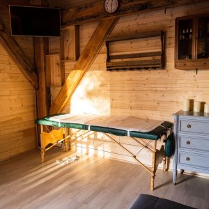 Hébergement insolite en bois avec un espace bien-être et un lit de massage.