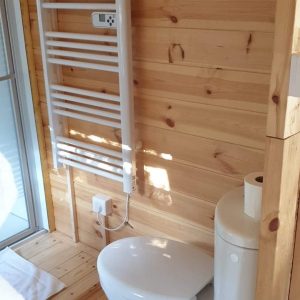 Toilette moderne dans un hébergement insolite en bois, ambiance chaleureuse.