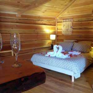 Cabane en bois cosy en Auvergne, lit douillet avec décor romantique.
