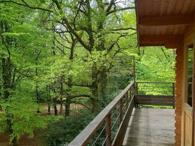 Cabane en bois perchée, offrant une vue sur la verdure luxuriante des Midi-Pyrénées.