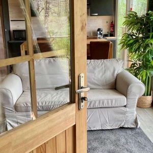 Hébergement insolite en Midi-Pyrénées : un salon lumineux avec canapé et verdure.