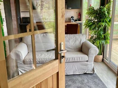 Hébergement insolite en Midi-Pyrénées : un salon lumineux avec canapé et verdure.
