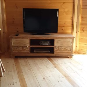 Hébergement insolite en bois avec un intérieur chaleureux et un téléviseur moderne.