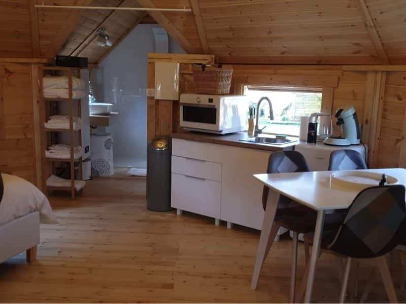 Chalet en bois lumineux avec cuisine équipée et coin repas confortable.