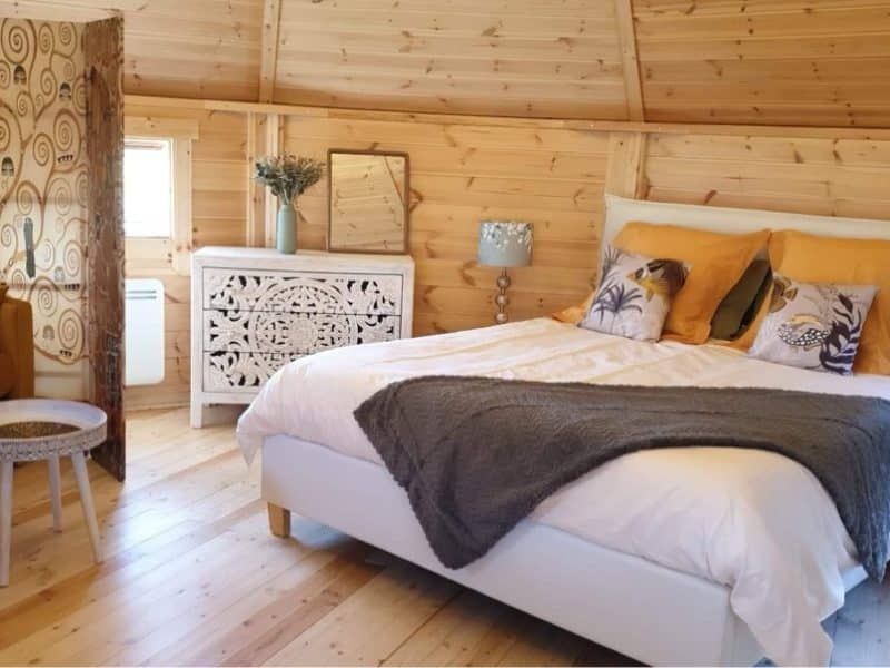 Chalet en bois chaleureux avec lit douillet et décor élégant. Parfait pour un séjour relaxant.