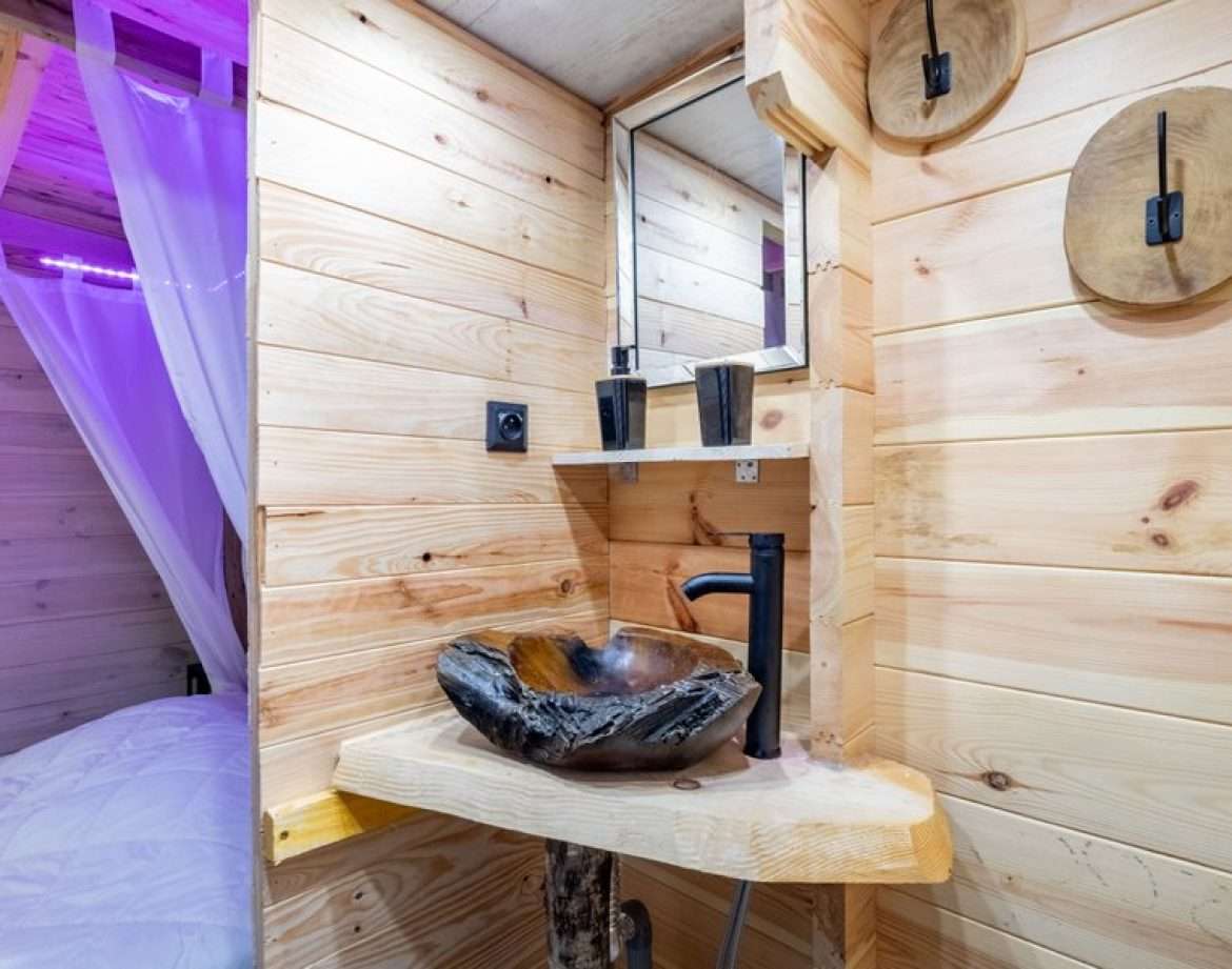 Hébergement insolite en bois avec lavabo en pierre et décor naturel à Midi-Pyrénées.