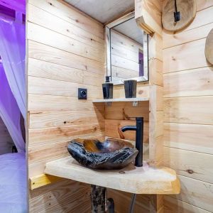 Hébergement insolite en bois avec lavabo en pierre et décor naturel à Midi-Pyrénées.