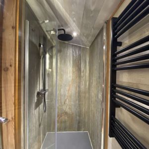 Douche moderne dans un hébergement insolite en Midi-Pyrénées, ambiance bois chaleureuse.