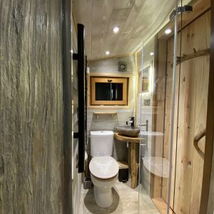 Salle de bain moderne dans un hébergement insolite en Midi-Pyrénées, bois et verre.