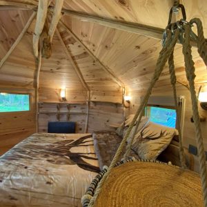 Cabane en bois dans les Midi-Pyrénées, intérieur chaleureux avec lit douillet.