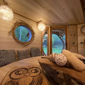 Cabane en bois à Midi-Pyrénées, avec un intérieur chaleureux et des luminaires originaux.