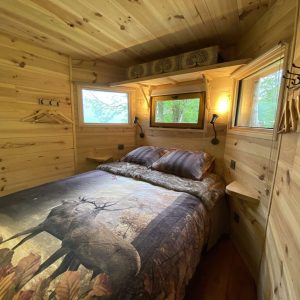 Cabane en bois à Midi-Pyrénées, lit douillet avec vue sur la nature.