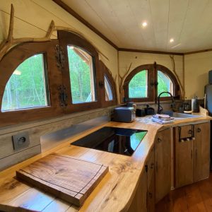 Hébergement insolite en Midi-Pyrénées : chalet en bois avec fenêtres arrondies.
