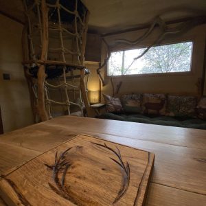 Cabane en bois avec un intérieur chaleureux et des éléments naturels décoratifs.