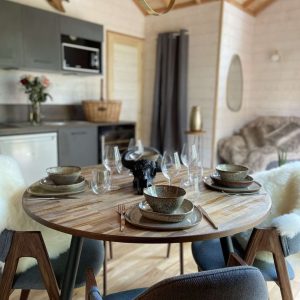 Hébergement insolite en Auvergne : chalet moderne avec coin repas élégant et décor chaleureux.